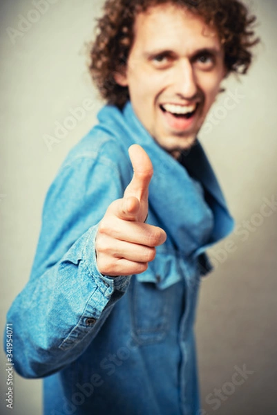 Fototapeta curly-haired man mockingly pointing finger