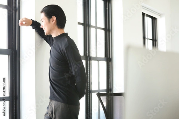 Fototapeta businessman standing in front of window office building