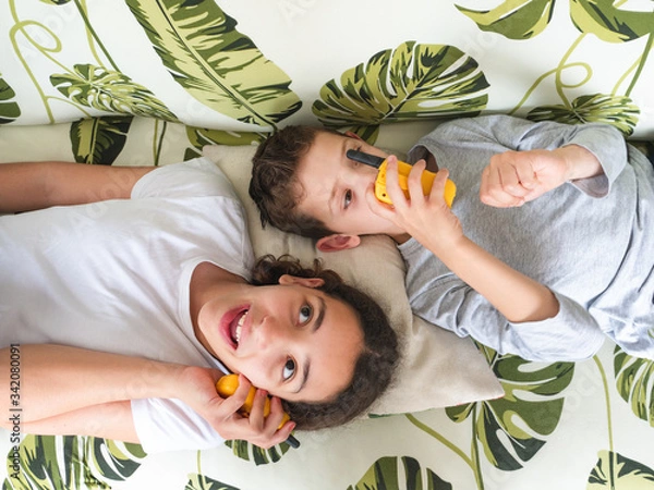 Obraz top view of two children playing with walkie talkie, communication concept