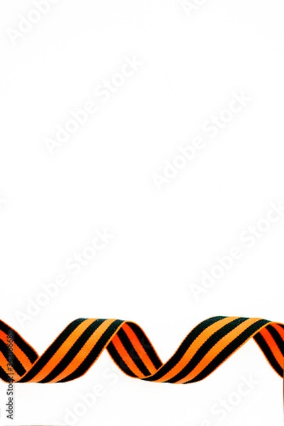Fototapeta orange and black striped ribbon symbol on May 9 and 23 February. Victory day St George ribbon. Victory day greeting card concept, copy space