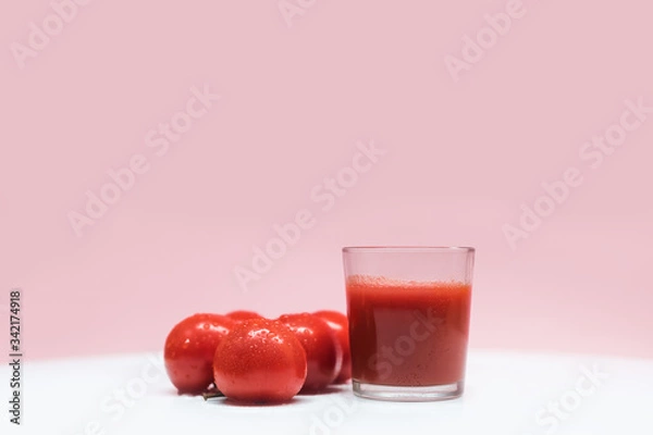 Obraz Fresh tomato juice and tomatoes on the background. A glass of freshly squeezed tomato juice. Healthy eating and healthy lifestyle.