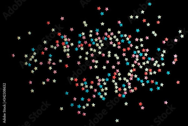 Fototapeta multicolored confectionery sprinkle in the form of stars on a black background