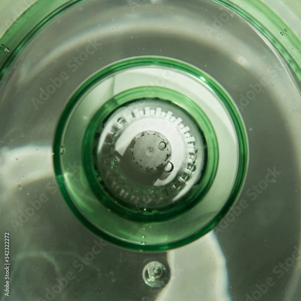 Fototapeta Close-up of a jug with a water purification cartridge. Green. The cartridge shows air bubbles under the water. square
