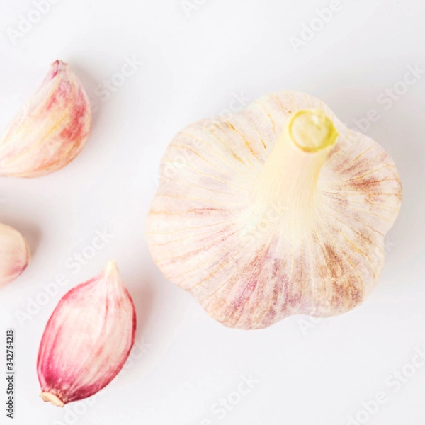 Fototapeta light fresh garlic with cloves lying side by side on a white background isolate