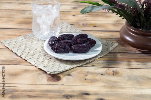 Fototapeta Dates and ice water on the wooden table and selective focus