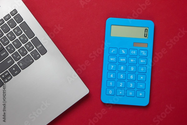 Fototapeta Calculator and laptop on red background. Top view