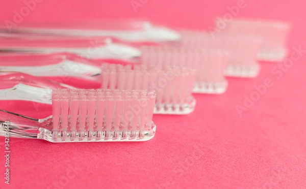 Obraz Plastic toothbrushes on a pink background close up