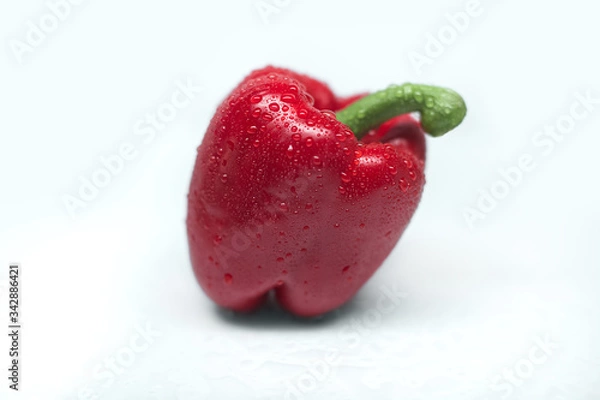 Obraz Close-up of fresh red bell pepper isolated on a gray background. Washed pepper with drops of water on the table. Healthy lifestyle. Seasonal and summer vegetables