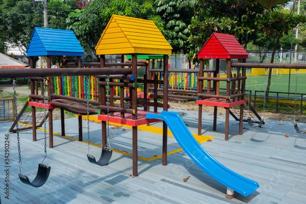 Obraz Empty and lonely chain black kid toddler children's swing on grey wooden structure playground. In Medellin, Colombia. Horizontal format.