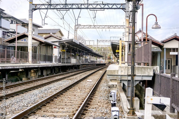 Fototapeta Perspective and outside view of Metal railroad track at Nara train platform on blue sky background.