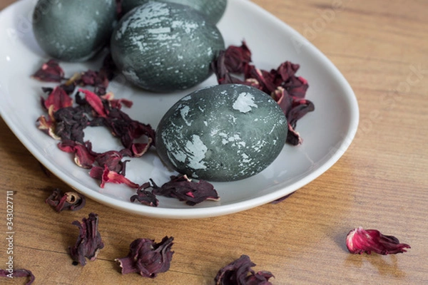 Fototapeta painted Easter eggs dark with spots on a white plate