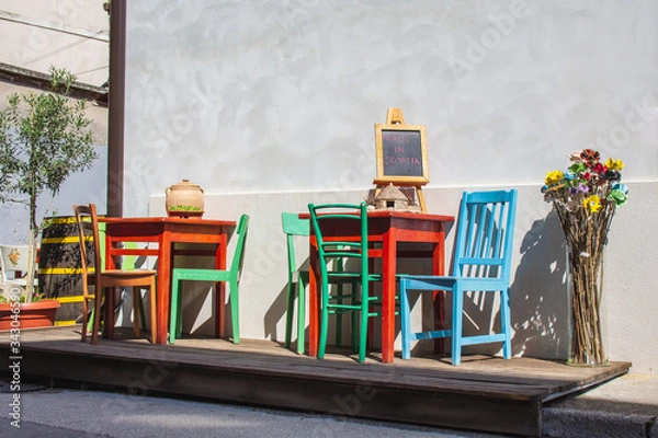 Fototapeta colorful chairs and tables in front of a restaurant in the old town of Pula, Istrian Peninsula, Croatia