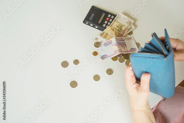 Fototapeta close-up of an elderly woman's hand counting coins Russian rubles on the background of a first-aid kit with medicines on a white table background place for text