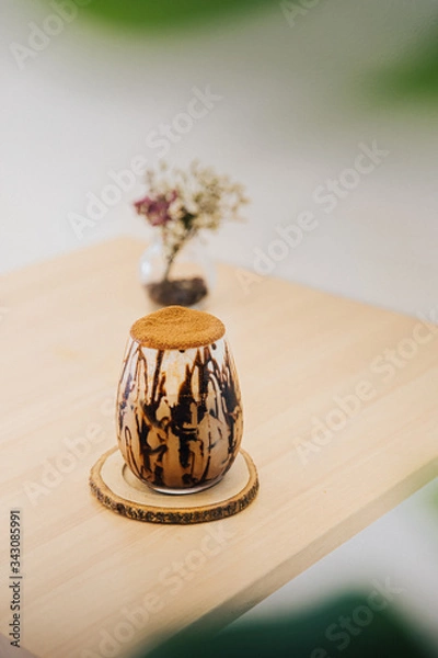 Obraz Chocolate Mocha with coco power as toping place oh the wood table with dried flower.