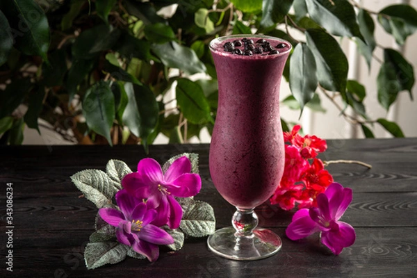 Fototapeta Cocktail with fruits and berries in a tall glass on a dark background