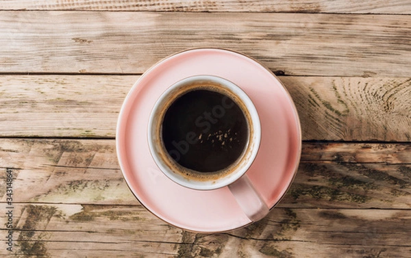 Fototapeta A pink cup of fresh coffee on a rustic wooden background. Minimal concept. Top view