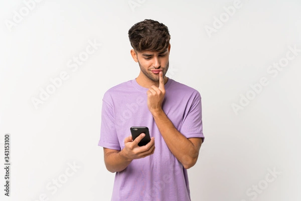 Fototapeta Young handsome man over isolated white background thinking and sending a message
