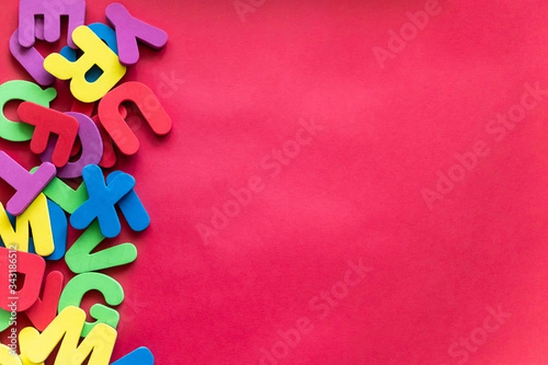 Fototapeta Letters of The Alphabet in Different Colors on a Red Background. Alphabet Study, ABC, Education Concept