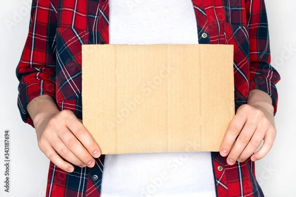 Fototapeta Woman in shirt hold empty cardboard. Template for text.