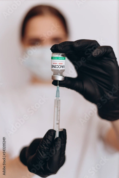 Fototapeta Doctor holds COVID 19 Coronavirus vaccine in his hand, Vaccine and syringe injection It use for prevention, immunization and treatment from COVID-19