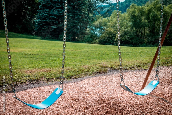 Obraz Empty swings on a swingset at a park during the summer