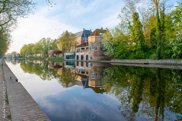 Fototapeta Canal view of a beautiful historical building/architecture in Delft.