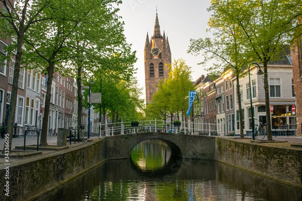 Fototapeta The 'Oude Jan' church viewed from the canal Delft.