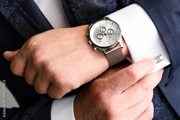 Obraz Businessman adjusts his white shirt cuff .