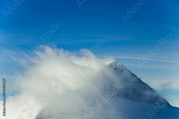 Fototapeta Rocky top Austrian Alps shrouded in cloud