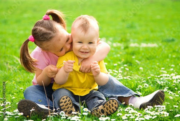 Obraz Two children are sitting on green meadow
