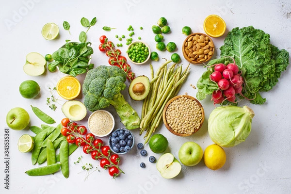 Fototapeta Assortment flat lay with healthy vegetarian meal ingredients. Raw food concept. A variety of organic fruits, nuts, berries and vegetables with avocado. Vegan menu.