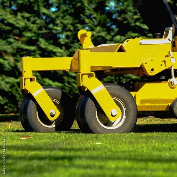 Fototapeta Lawn mower park in green grass field, zero turn Lawn mower.

