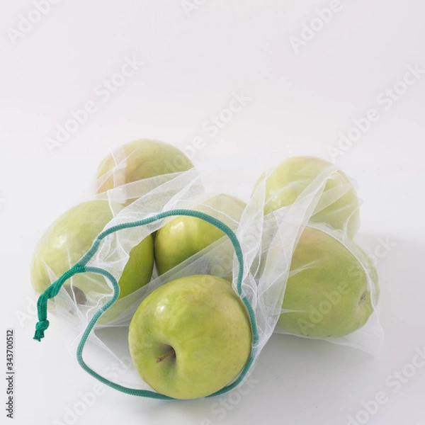 Fototapeta Zero waste, plastic free recycled textile produce bag for carrying fruit apples or vegetables, a white surface. Reusable using. Copy space.