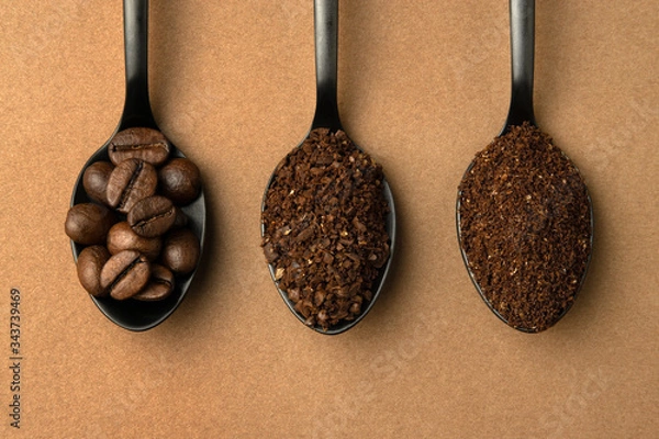 Fototapeta Coffee beans and different grinding coffee - coarse coffee, finely ground coffee in black spoons. Top view close-up.