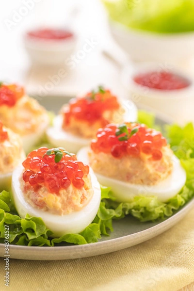 Fototapeta Stuffed eggs with red caviar.