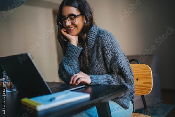 Obraz Happy smiling young woman using laptop computer device while working remotely at home office, Cheerful businesswoman in casual clothes having video meeting via laptop, Video Chat Communication Concept