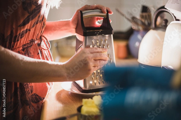 Fototapeta Grating cheese with grater