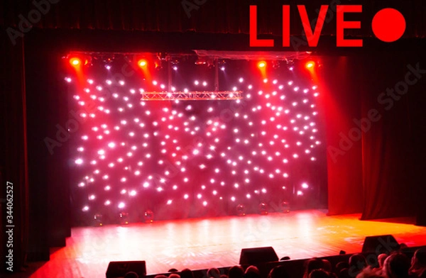 Obraz Text LIVE and red circle on blurred show background. Empty stage and sparkling stage lights at time of entertainment show. Concept live performance concert on the Internet, online show