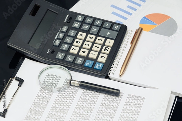 Fototapeta Business financial documents, office calculator and pen on the table. Numbers and graphs