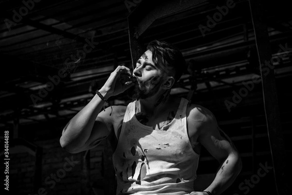 Fototapeta guy on a break smokes a cigarette, bearded man with sports figure.