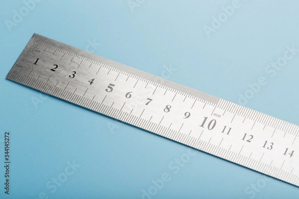 Fototapeta Metal ruler on a blue background close-up with a copy of the space for your text.