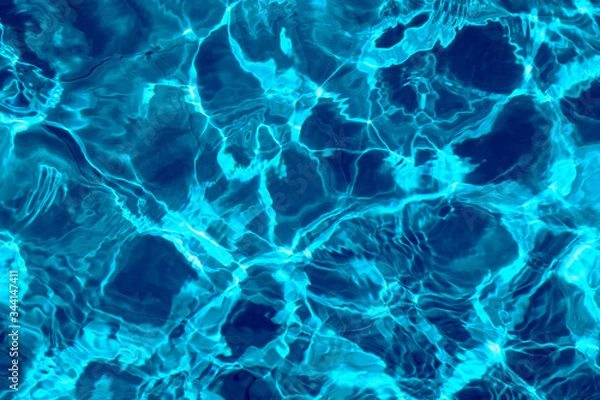 Fototapeta ripple water in swimming pool with sun reflection. blue water background texture