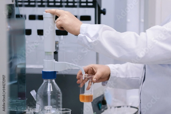 Fototapeta Scientist holding a test tubes, Laboratory research. Scientist with test tube making research in clinical laboratory.