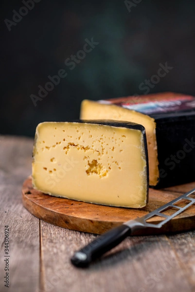 Obraz Medium hard cheese head gouda edam on wooden board with knife wooden texture daylight