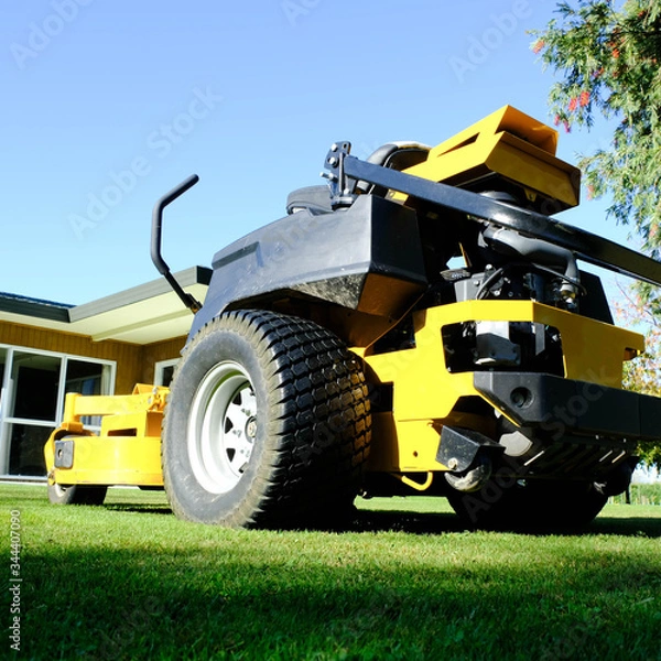 Fototapeta Lawn mower park by green grass field, zero turn Lawn mower.
