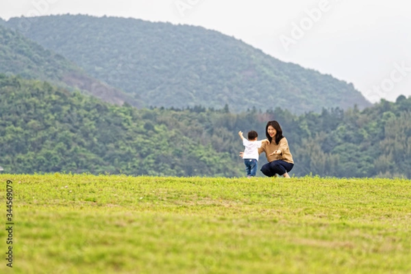 Fototapeta Mother and son play on the lawn