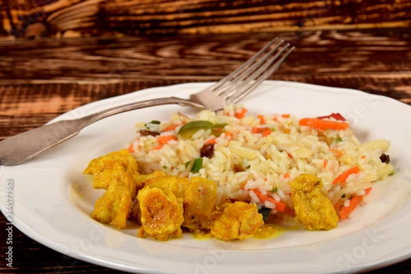 Fototapeta colorful rice with vegetables and pieces of chicken in a curry spice