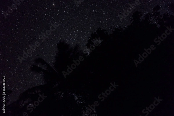 Obraz Two falling stars cross each other in nigh sky over the jungle in Banda islands, Maluku, eastern Indonesia