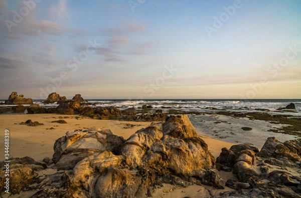 Obraz Nice lava rock formations at undiscovered beachlighted in golden evening glow found in Sawarna, Banten, Java, Indonesia