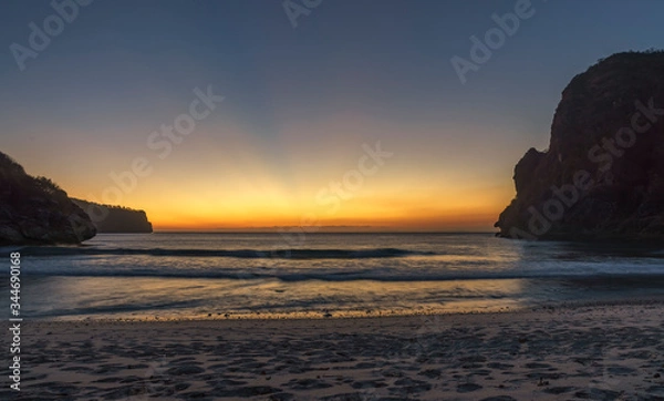 Obraz Remarkable gradual sunset or sunrise at undiscovered remote beach surrounded by high rock hills in west Sumbawa island